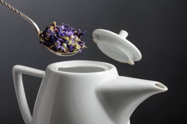 Dried mallow flowers are poured into the teapot. Selective focus. clipart