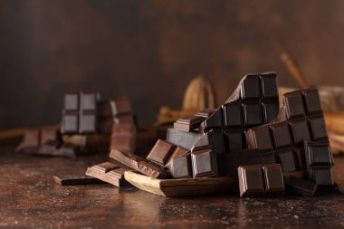 Kahverengi bir arka planda kırık acı ve sütlü çikolatalar..