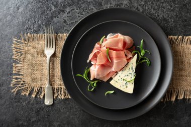 Mavi peynir, prosciutto, ve biberiye bir Blackstone masasında. Üst görünüm.