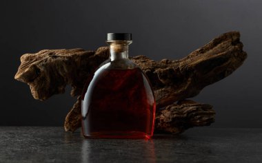 Bir şişe brendi ve siyah arka planda eski bir pürüz. Boşluğu kopyala.