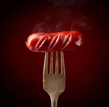 Izgara sosis ve çatal. Koyu kırmızı arkaplan, alanı kopyala. 