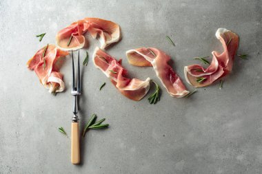 Eski beton arka planda biberiyeli Prosciutto. Geleneksel Akdeniz yemeği. Üst görünüm.