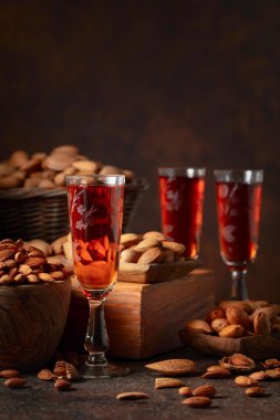 Kahverengi arka planda badem fıstıklı İtalyan likörü Amaretto..