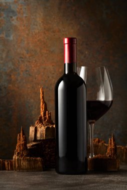 Paslı arka planda eski ahşap parçaları olan cam ve bir şişe kırmızı şarap. Etiketini şişenin üzerine koy..