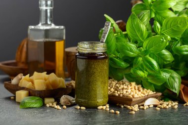 Pesto sosu ve malzemeler siyah taş bir masada. Geleneksel İtalyan pesto tarifi.