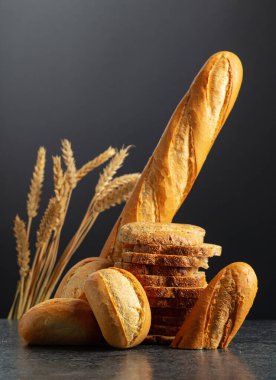 Siyah arka planda ekmek ve buğday kulakları. Boşluğu kopyala.