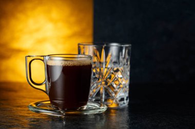 Siyah taş bir masada espresso ve bir bardak soğuk su. Boşluğu kopyala.