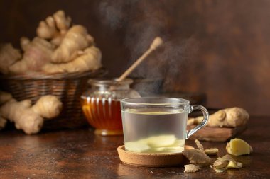 Kahverengi arkaplanda zencefilli çay ve bal.