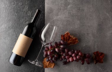 Arka planda üzümlü kırmızı şarap. Boş bir şişede. Üst görünüm.
