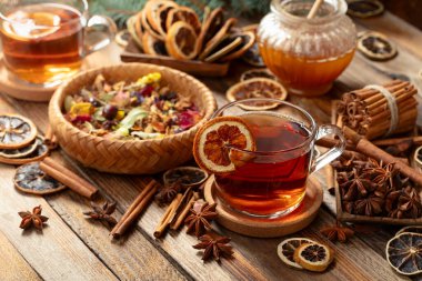 Tarçın, anason ve kuru narenciye dilimli Noel çayı. Eski ahşap bir masada malzemeli bitki çayı..
