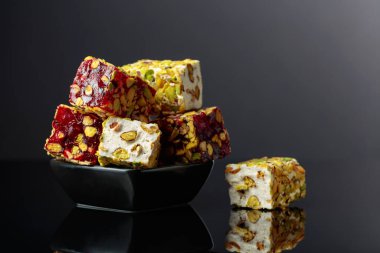 Siyah yansıtıcı arka planda küçük siyah bir tabakta geleneksel Türk zevki. Boşluğu kopyala.