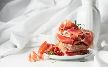 Ciabatta prosciutto ve biberiyeli beyaz ahşap masa. Geleneksel İtalyan atıştırması.
