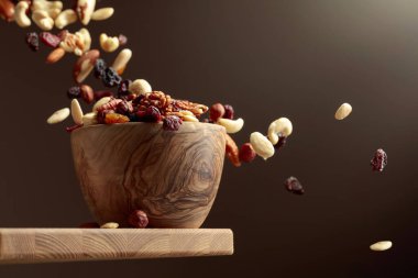 Uçan kurutulmuş meyve ve fındık. Fındık ve kuru böğürtlen karışımı ahşap bir kasede.. 