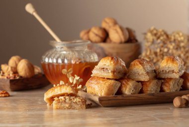 Bej arka planda ceviz ve bal olan baklava. Geleneksel Doğu Çölü ahşap tabakta. Boşluğu kopyala.