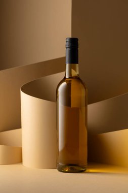 Bottle of white wine on a beige background. Copy space.