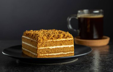 Geleneksel ballı kek ve siyah arka planda sade kahve. Boşluğu kopyala.