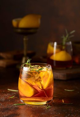 Buzlu çay veya eski kahverengi masada buzlu, biberiyeli ve limonlu alkollü kokteyl. Taze, sağlıklı, soğuk limon suyu. Buzlu ve limonlu çay..