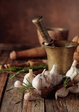 Eski ahşap bir masada biberiyeli sarımsak soğanı. Boşluğu kopyala.