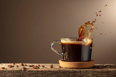 Kahverengi arka planda cam bardakta sade kahve. Boşluğu kopyala.