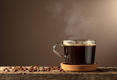 Eski bir tahtanın üzerinde cam bardakta sade kahve. Boşluğu kopyala.