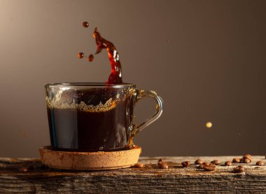 Kahverengi arka planda cam bardakta sade kahve. Boşluğu kopyala.