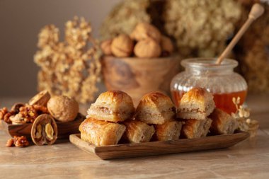 Bej arka planda ceviz ve bal olan baklava. Geleneksel Doğu Çölü ahşap tabakta. Boşluğu kopyala.