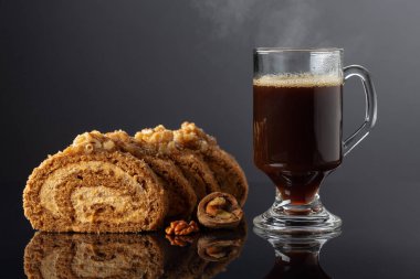 Cevizli tatlı ve siyah yansıtıcı arka planda kahve. Kahverengi şeker, ceviz ve kremalı kek. Boşluğu kopyala.