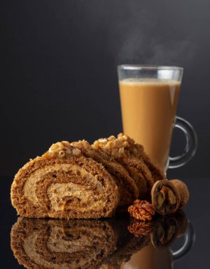 Cevizli tatlı ve siyah yansıtıcı arka planda kahve. Kahverengi şeker, ceviz ve kremalı kek. Boşluğu kopyala.