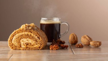 Cevizli tatlı ve bej arka planda kahve. Kahverengi şeker, ceviz ve kremalı kek. Boşluğu kopyala.