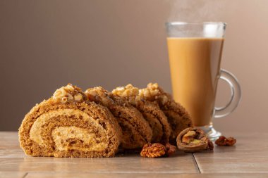 Cevizli tatlı ve bej arka planda kahve. Kahverengi şeker, ceviz ve kremalı kek. Boşluğu kopyala.