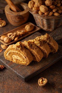 Kahverengi arka planda cevizli tatlı. Kahverengi şeker, ceviz ve kremalı kek..