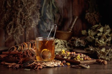 Bir fincan bitkisel çay, çeşitli kurutulmuş bitkiler, çiçekler ve baharatlar. İçindekilerle çay ve kurutulmuş narenciye..