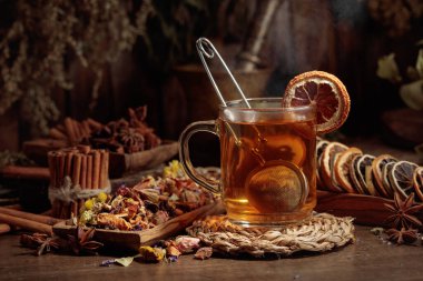 Bir fincan bitkisel çay, çeşitli kurutulmuş bitkiler, çiçekler ve baharatlar. İçindekilerle çay ve kurutulmuş narenciye..