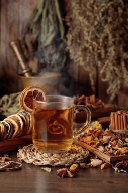 Bir fincan bitkisel çay, çeşitli kurutulmuş bitkiler, çiçekler ve baharatlar. İçindekilerle çay ve kurutulmuş narenciye..