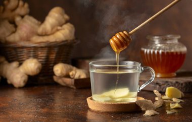 Kahverengi arkaplanda zencefilli çay ve bal.