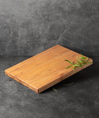 Gri taşlı arka planda biberiyeli boş kesim tahtası. Boşluğu kopyala.