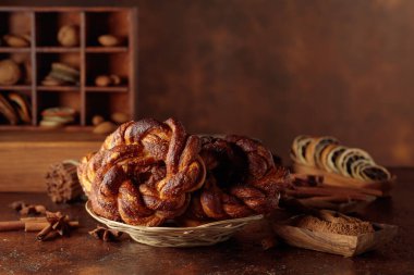 Kahverengi mutfak masasında tarçınlı ve şekerli ev yapımı simit. Boşluğu kopyala