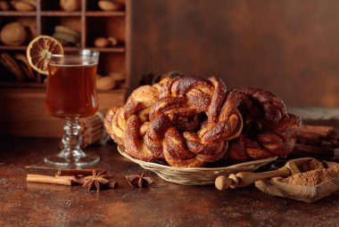 Kahverengi arka planda tarçınlı ve şekerli ev yapımı simit..