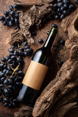Bir şişe kırmızı şarap, mavi üzümler ve yıpranmış eski parçalar. Eski boş bir şişede. Metninizi etikete yerleştirin.