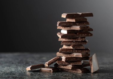 Siyah arka planda kırılmış acı çikolata. Boşluğu kopyala.