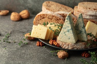 Mutfak masasında peynir, ekmek, ceviz ve kekik. Boşluğu kopyala.