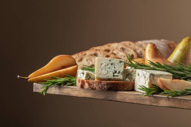 Mavi peynirli, armutlu ve biberiyeli sandviç. Eski ahşap bir masada ciabatta, mavi peynir, armut ve biberiye.