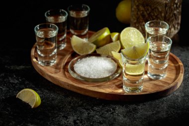 Tahta tepside tuz ve limon dilimli altın tekila. Boşluğu kopyala.