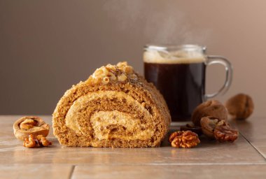 Cevizli tatlı ve bej arka planda kahve. Kahverengi şeker, ceviz ve kremalı kek. Boşluğu kopyala.