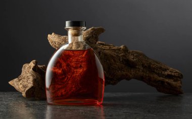Bir şişe brendi ve siyah arka planda eski bir pürüz. Boşluğu kopyala.