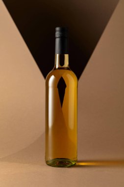 Bottle of white wine on a beige background. Copy space.