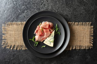 Mavi peynir, prosciutto, ve biberiye bir Blackstone masasında. Üst görünüm.