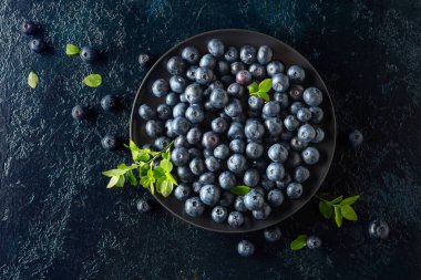 Siyah bir arka planda siyah tabakta yaban mersini. Üst görünüm.