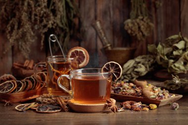 Çeşitli kurutulmuş otlar, çiçekler ve baharatlarla dolu bir fincan bitki çayı. İçindekilerle çay ve kurutulmuş narenciye..