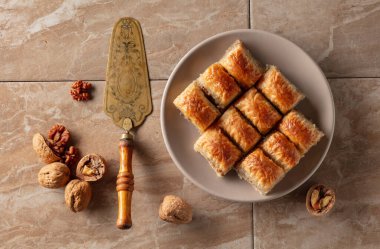 Bej bir tabakta cevizli baklava. Üst görünüm.